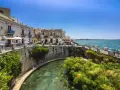 Passeggiata sul lungomare di Ortigia, Siracusa, ideale per un tour sicilia sud orientale 7 giorni. L'acqua cristallina e i papiri incantano.