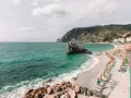 Una delle spiagge più belle della Liguria, con mare cristallino, scogli e un'infinità di ombrelloni colorati.
