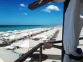 Ombrelloni bianchi e lettini ordinati sulla sabbia dorata, con il mare azzurro e il cielo limpido a fare da sfondo. Un'immagine perfetta di mamire lido Marini.