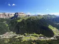 Panoramica delle Dolomiti, ideale per scoprire cosa vedere in Trentino in 3 giorni: valli verdi, boschi fitti e villaggi alpini sotto maestose cime rocciose.