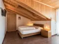 Camera accogliente con tetto in legno e letto matrimoniale. Un'oasi di pace all'hotel Weingarten Kaltern.