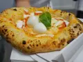 Pizza Margherita appena sfornata, con mozzarella di bufala e basilico fresco. Un vero assaggio di cibo napoletano.