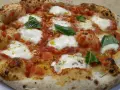 Pizza margherita con mozzarella filante, pomodoro e basilico fresco. Una vera casa matta, nota per la sua bontà.