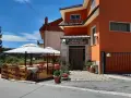 Ristorante La Vecchia Fonte, con tavoli all'aperto sotto ombrelloni bianchi, in una giornata di sole.