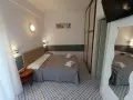 Camera accogliente con letto matrimoniale, biancheria fresca e un tavolino. Le recensioni per Hotel Le Terrazze Riccione confermano la comodità.