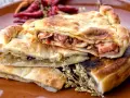 Pasticcio ripieno, un'idea su cosa mangiare a Gaeta. Ripieno di pesce e verdure, con peperoncini secchi sullo sfondo.