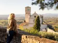 Donna ammira il panorama di Assisi, con la Basilica di San Francesco in lontananza. Un ricordo di viaggio tra Assisi e Gubbio.