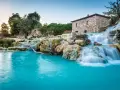 Cascate naturali con acqua turchese e un antico mulino in pietra. Un'oasi di pace, perfetta per un inverno nelle terme in Italia.