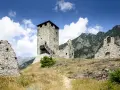 Rovine di un castello con torre in pietra, un invito a visitare la Valle d'Aosta.