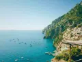 Positano, una delle perle delle regioni d'Italia, si affaccia sul mare blu con case colorate aggrappate alla scogliera.