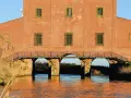 Antico edificio con ponte ad archi su un canale, un luogo suggestivo da scoprire a Castiglione della Pescaia.