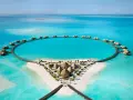 Resort circolare su un'isola tropicale, perfetto per le tue vacanze ad agosto. Case sull'acqua e sabbia bianca.