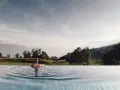 Donna rilassata in piscina a sfioro con vista sulle montagne, un'esperienza indimenticabile all'hotel Milla Montis.