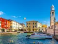 Lazise: cosa vedere nel borgo sul lago. Case colorate, porto con barche e campanile.