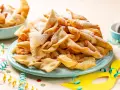 Dolci fritti a forma di fiocco, cosparsi di zucchero a velo, sono un classico di cosa si mangia a Carnevale in Italia.