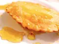 Dolce fritto, uno dei 5 piatti tipici della Sardegna, ricoperto di miele dorato.
