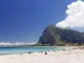 Spiaggia di San Vito Lo Capo, Sicilia, con il Monte Monaco imponente sullo sfondo e il mare cristallino che invita a un bagno.