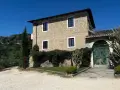La Masseria del Carmine Maggiore, con le sue mura in pietra chiara e il verde rigoglioso, incanta sotto un cielo azzurro.