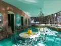 Veranda luminosa della villa dei cipressi a Sona, con pavimenti verdi, mobili in vimini e un grande divano curvo con cuscini colorati.