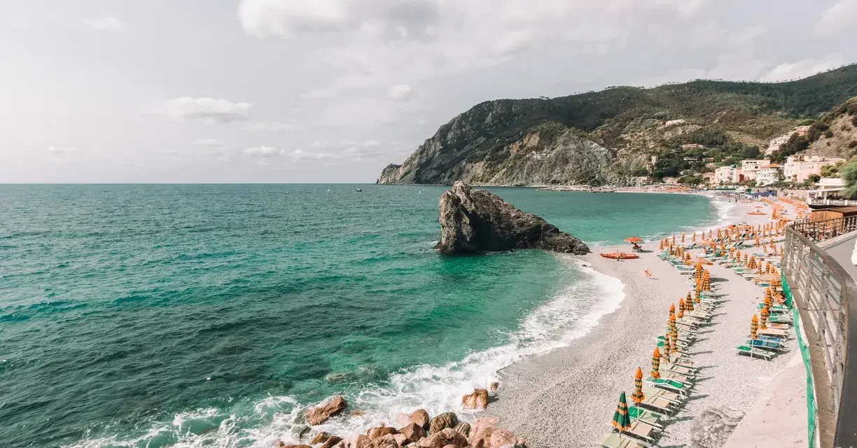 Una delle spiagge più belle della Liguria, con mare cristallino, scogli e un'infinità di ombrelloni colorati.