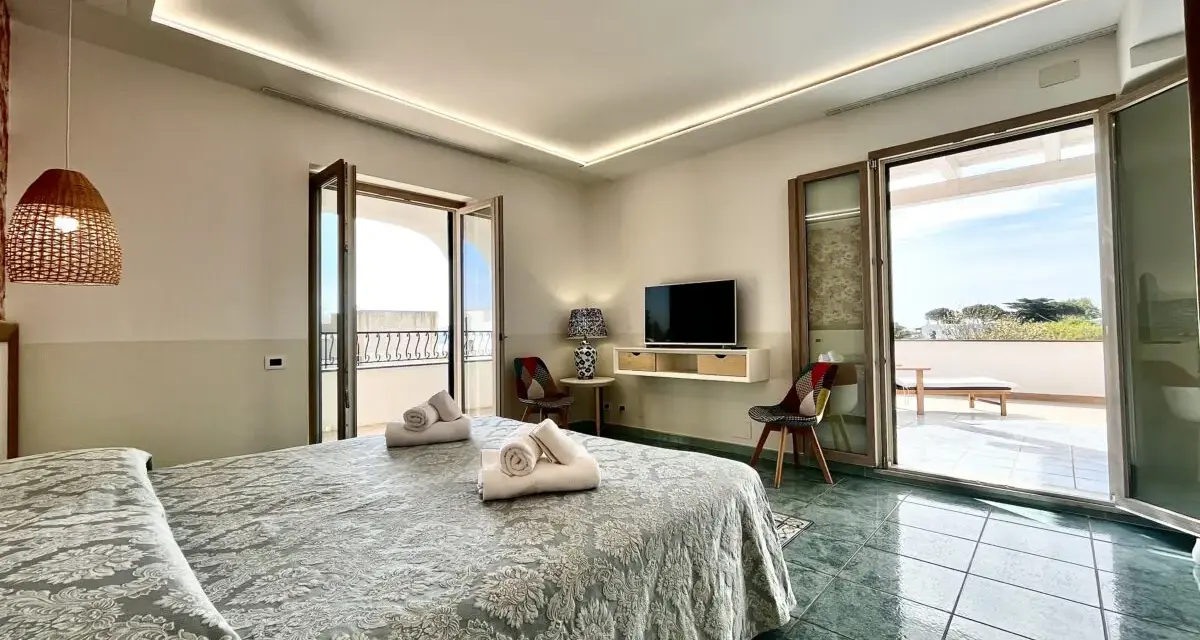 Camera da letto con vista mare al **hotel Lo Smeraldo Ventotene**. Letto matrimoniale, TV, balcone e arredi moderni.