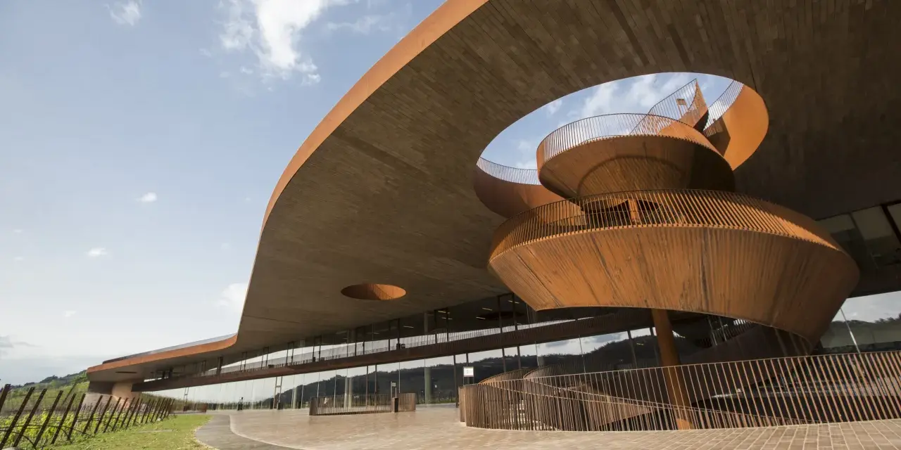 Edificio moderno con scala a chiocciola in corten, un esempio di cantine da visitare con architettura audace.