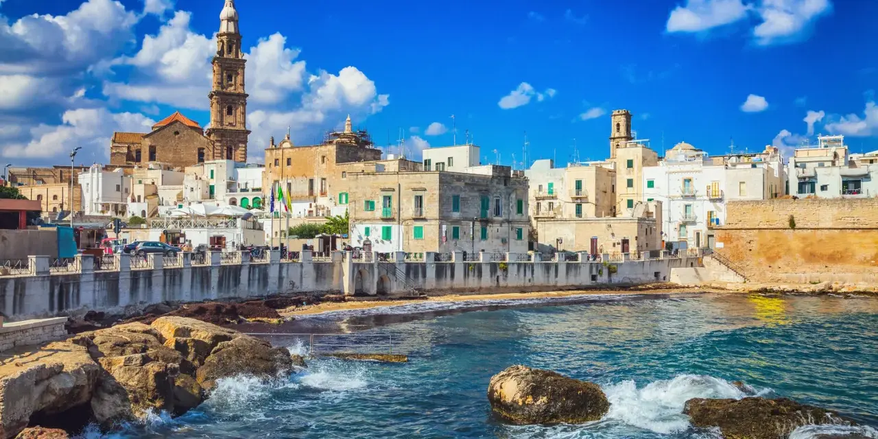 Vista sul mare di Bari Vecchia, con case bianche e torri che si affacciano sull'acqua cristallina. Un luogo incantevole da vedere.