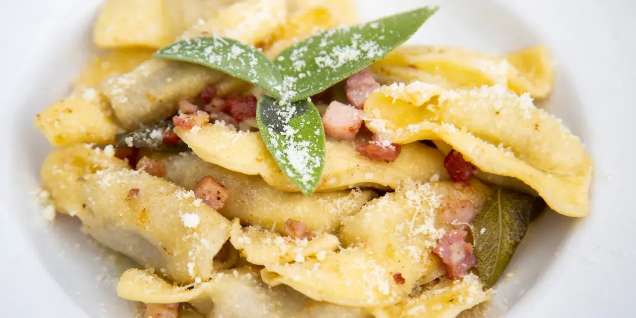 Casoncelli alla bergamasca, un classico dei piatti tipici bergamaschi, conditi con burro, salvia e pancetta croccante, spolverati di grana.