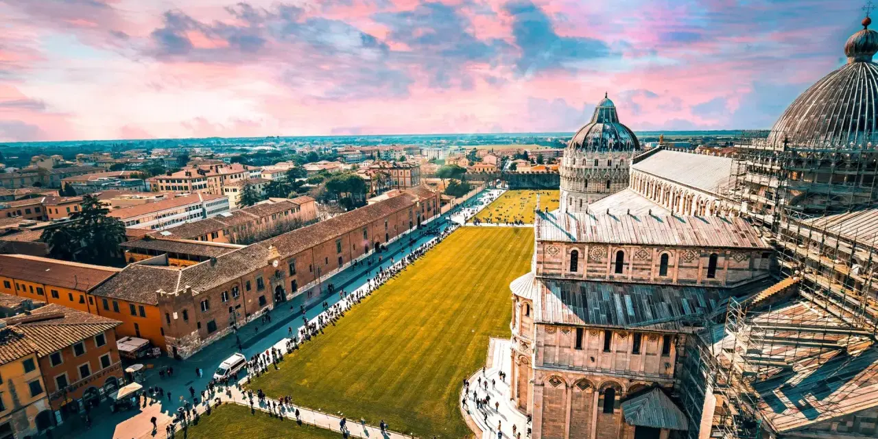 Un suggestivo itinerario Toscana 5 giorni inizia con la Piazza dei Miracoli a Pisa, con la sua cattedrale e il battistero sotto un cielo rosa.