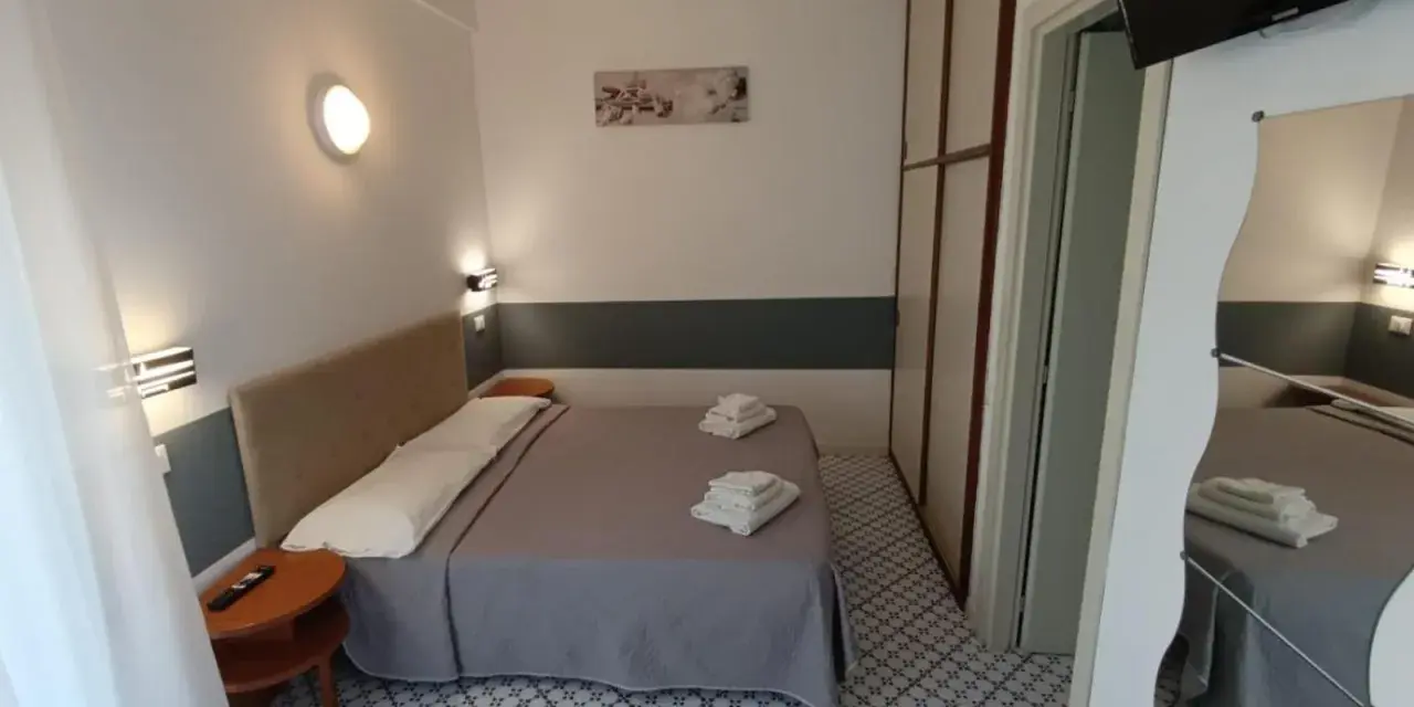 Camera accogliente con letto matrimoniale, biancheria fresca e un tavolino. Le recensioni per Hotel Le Terrazze Riccione confermano la comodità.