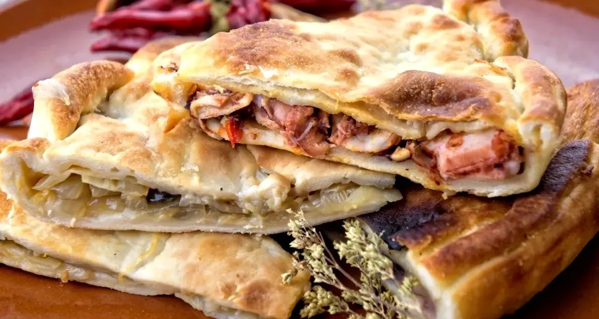 Pasticcio ripieno, un'idea su cosa mangiare a Gaeta. Ripieno di pesce e verdure, con peperoncini secchi sullo sfondo.