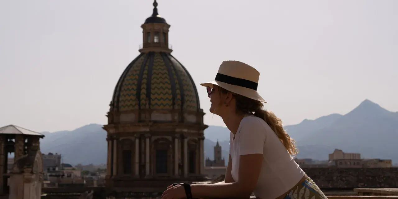Vista panoramica di Palermo con una donna che ammira la cupola. Un'idea di cosa vedere a Palermo in 3 giorni.