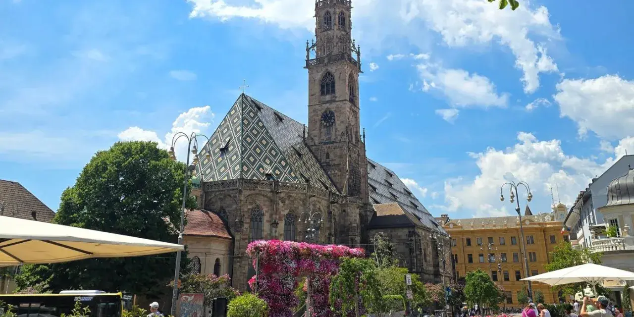 Piazza Duomo a Bolzano, con la cattedrale e aiuole fiorite. Perfetto per scoprire cosa vedere a Bolzano in un giorno.