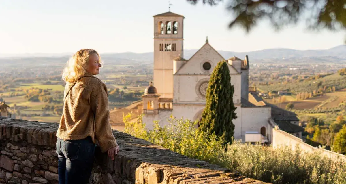 Donna ammira il panorama di Assisi, con la Basilica di San Francesco in lontananza. Un ricordo di viaggio tra Assisi e Gubbio.