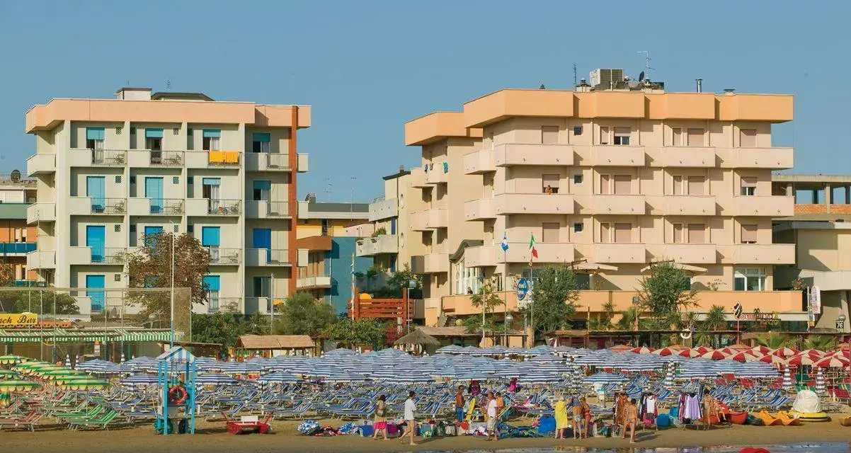 Edifici sul lungomare di Igea Marina, con molti ombrelloni e lettini sulla spiaggia. Le recensioni per hotel San Giorgio Savoia potrebbero menzionare questa vista.