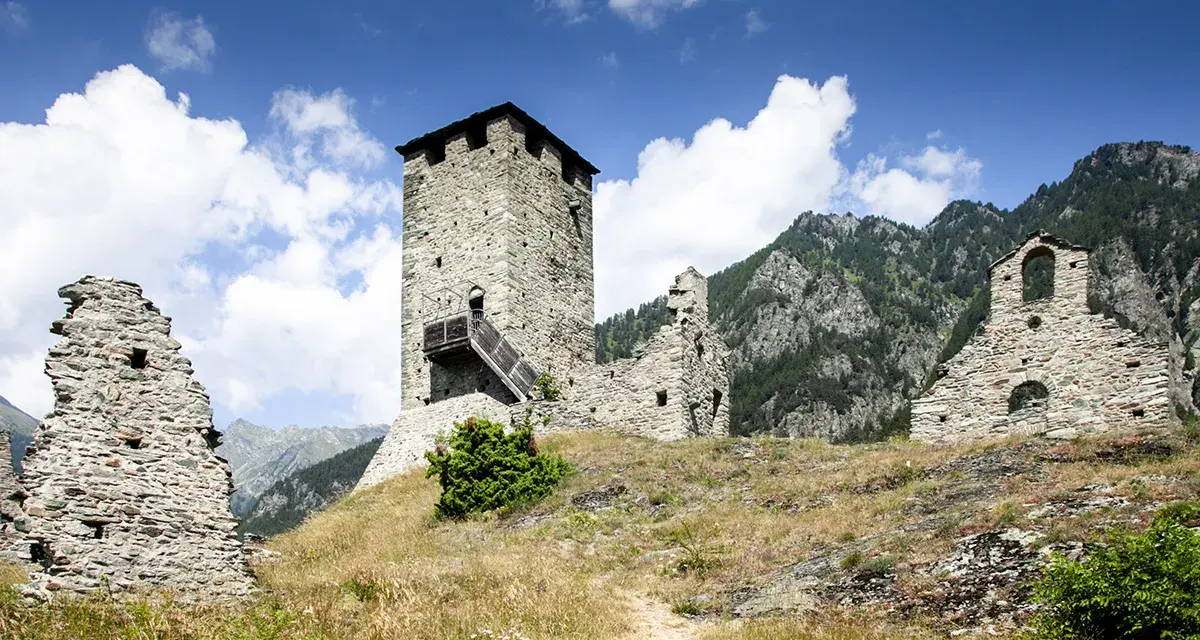 Rovine di un castello con torre in pietra, un invito a visitare la Valle d'Aosta.