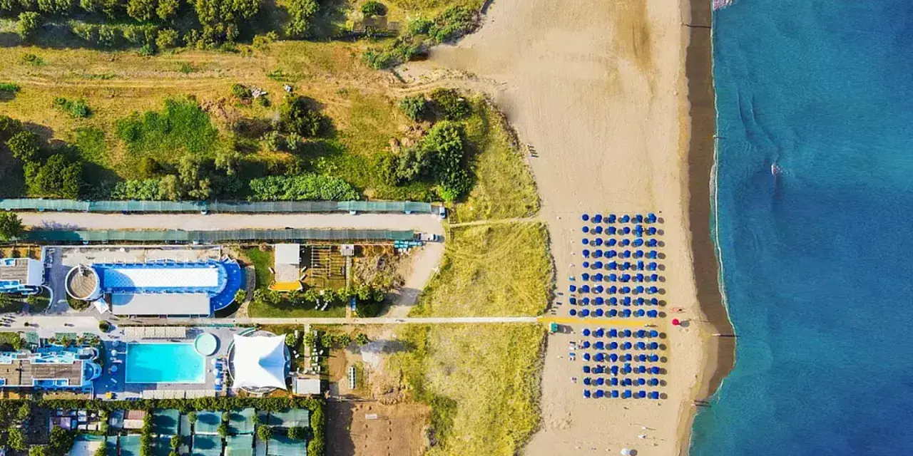 Villaggio vacanze a Paestum, spiaggia con ombrelloni blu e bianchi. Recensioni positive per questo coral beach.