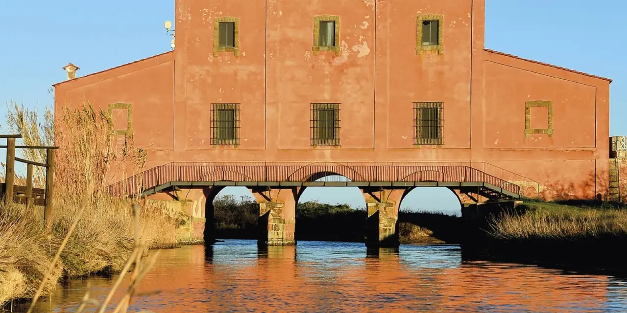 Antico edificio con ponte ad archi su un canale, un luogo suggestivo da scoprire a Castiglione della Pescaia.