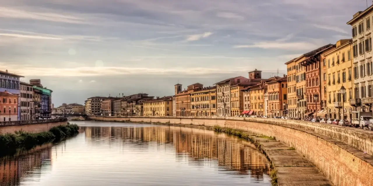 Lungarno a Pisa, con palazzi colorati che si specchiano nel fiume. Un'atmosfera da fiaba, tra Lucca e Pisa.