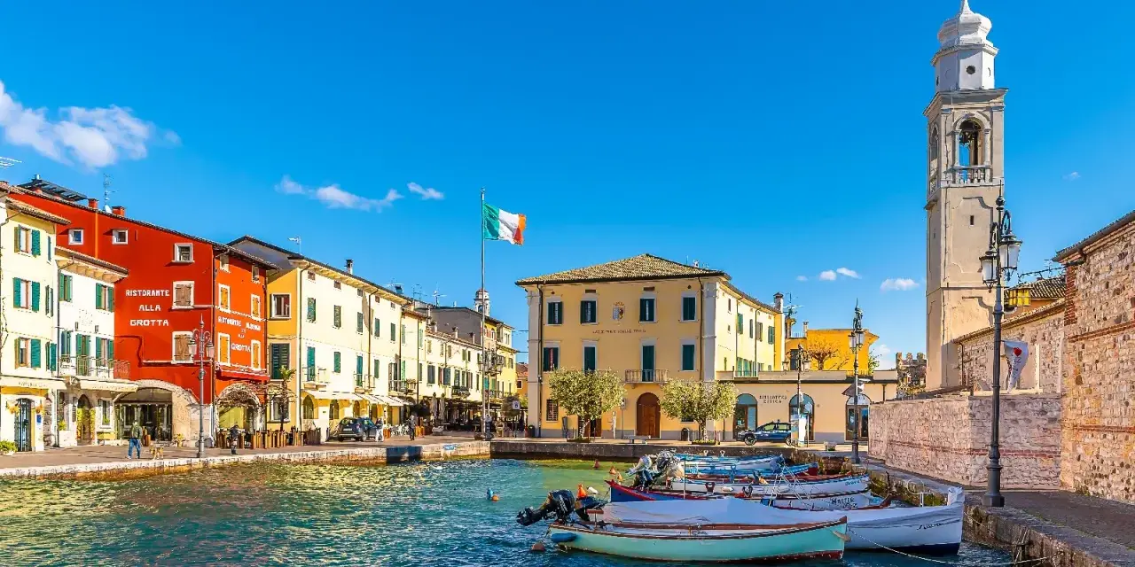 Lazise: cosa vedere nel borgo sul lago. Case colorate, porto con barche e campanile.