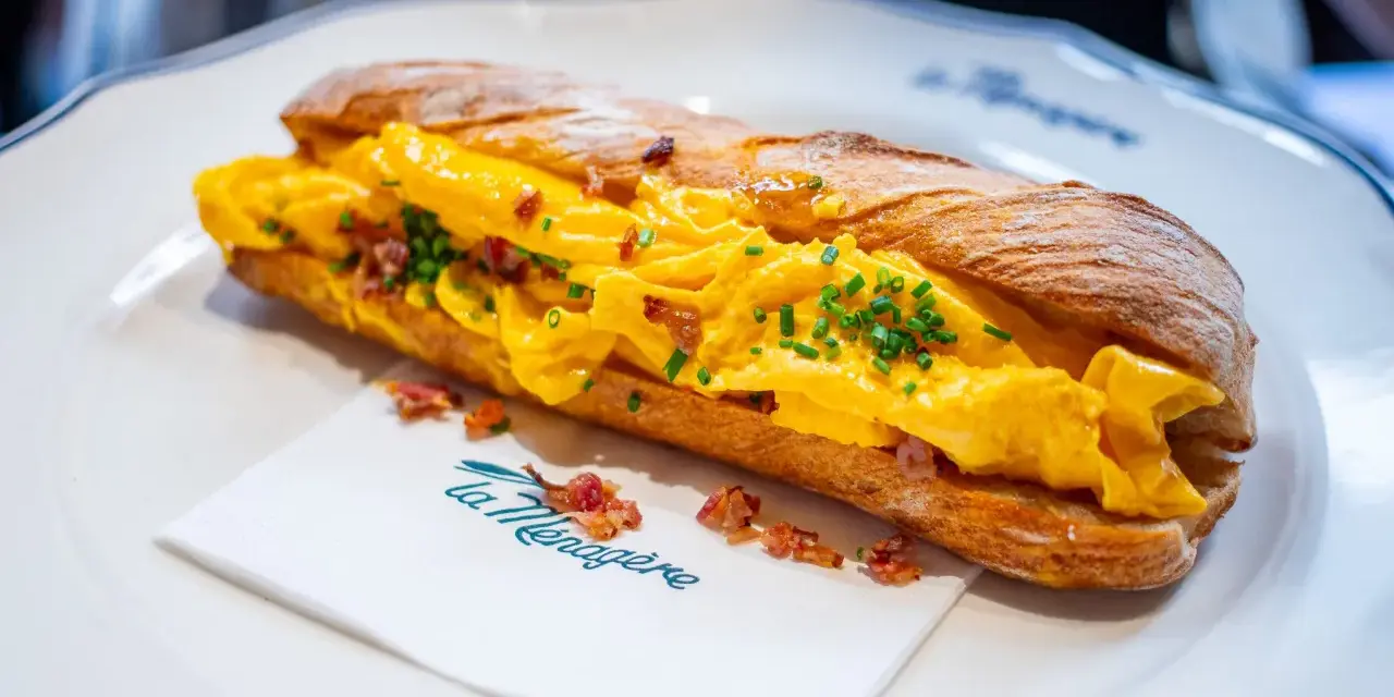 Panino con uova strapazzate, bacon croccante e erba cipollina. Un'ottima idea su cosa mangiare a Firenze per un pasto veloce e gustoso.