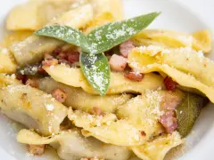 Casoncelli alla bergamasca, un classico dei piatti tipici bergamaschi, conditi con burro, salvia e pancetta croccante, spolverati di grana.