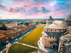 Un suggestivo itinerario Toscana 5 giorni inizia con la Piazza dei Miracoli a Pisa, con la sua cattedrale e il battistero sotto un cielo rosa.