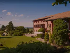 La casa rossa ai colli, immersa nel verde, offre un panorama incantevole. Un giardino curato con un antico attrezzo agricolo fiorito.