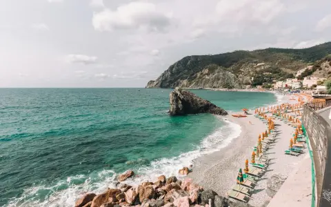 Una delle spiagge più belle della Liguria, con mare cristallino, scogli e un'infinità di ombrelloni colorati.