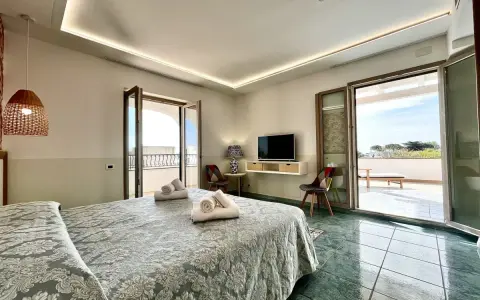 Camera da letto con vista mare al **hotel Lo Smeraldo Ventotene**. Letto matrimoniale, TV, balcone e arredi moderni.