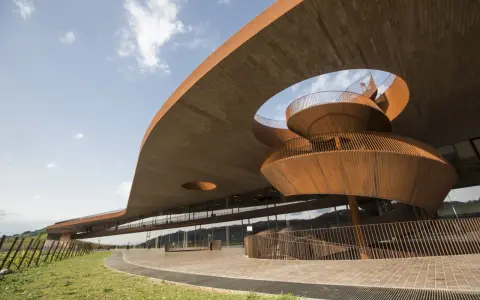 Edificio moderno con scala a chiocciola in corten, un esempio di cantine da visitare con architettura audace.