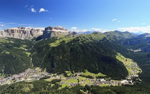 Panoramica delle Dolomiti, ideale per scoprire cosa vedere in Trentino in 3 giorni: valli verdi, boschi fitti e villaggi alpini sotto maestose cime rocciose.