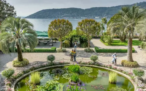 Giardini lussureggianti con laghetto di ninfee, palme e vista sul lago. Perfetto per scoprire cosa vedere a Stresa in un giorno.