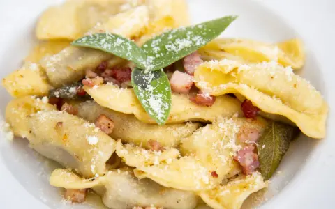 Casoncelli alla bergamasca, un classico dei piatti tipici bergamaschi, conditi con burro, salvia e pancetta croccante, spolverati di grana.